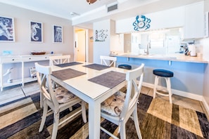 Una cocina moderna con armarios blancos, encimera azul y pileta de acero inoxidable.