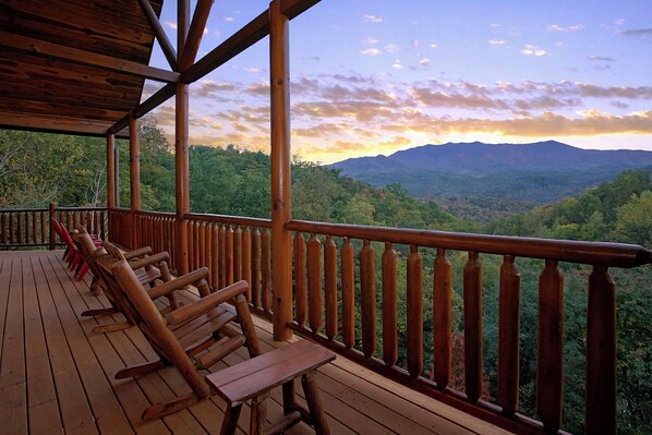 A wooden deck with benches and a table, overlooking a mountainous landscape. - Cabin w/Private Pool-Theater-Mountain View-Game Room (GATLINBURG)