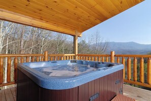 A wooden deck with a hot tub and a wooden railing. - Cabin w/Private Pool-Theater-Mountain View-Game Room (GATLINBURG)