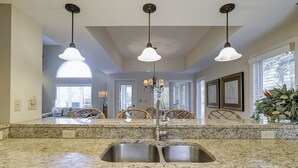 A kitchen with granite countertops, a double sink, and pendant lighting. - 7634 Huntington-Canal views, heated pool & spa.  Quick walk to Ocean. (Hilton Head Island)
