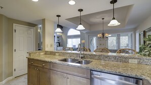 A kitchen with granite countertops, stainless steel appliances, wooden cabinets, and pendant lighting. - 7634 Huntington-Canal views, heated pool & spa.  Quick walk to Ocean. (Hilton Head Island)