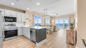 A modern kitchen with stainless steel appliances, a large island, and a view to the outside. - GULF FRONT CONDO! SLEEPS UP TO 6! (Panama City Beach)