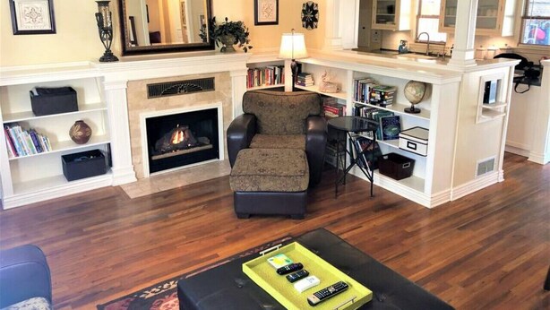 A living room with a fireplace, a sofa, a coffee table, and a bookshelf. - Peaceful Boise Bungalow, Short Drive to Downtown! (Boise)
