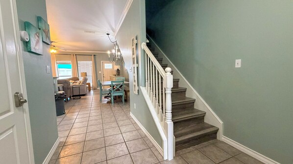 A home interior with a staircase, a dining area, and a living room.