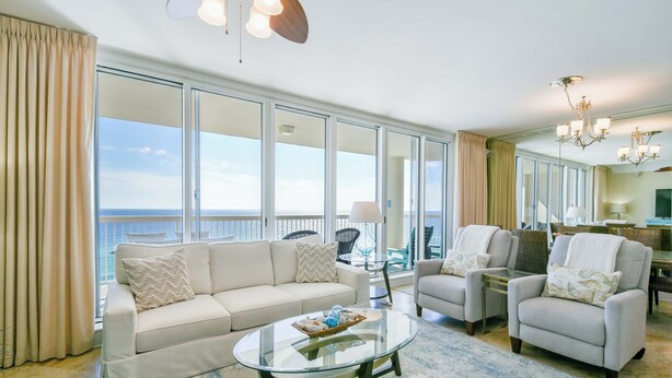 A spacious living room with a large glass table, two sofas, and a view of the ocean. - Updated, luxurious beachfront condo w/ Tempur-Pedic King in Master! 🌊 (Destin)