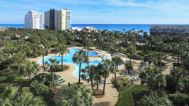 A resort with a central pool, palm trees, and beachfront views. - GULF VIEWS IN A  PREMIER RESORT!! GREAT RATES! (Destin)