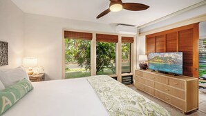 A hotel room with a bed, a television on a wooden cabinet, and a ceiling fan. - Manualoha 1102 Perfect AC throughout By Suite Paradise (Koloa)