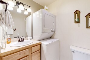 Enjoy a convenient bathroom with a sink, vanity, and washing machine for self-service laundry.