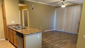 A kitchen with granite countertops, a dishwasher, and a built-in oven.