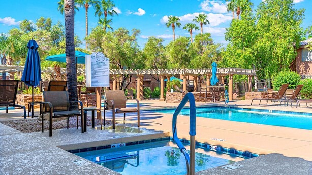Un espace piscine équipé de chaises longues, de parasols et d’un panneau d’affichage.