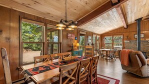 Un interior de madera con una mesa de comedor, sillas, un sofá y una chimenea.