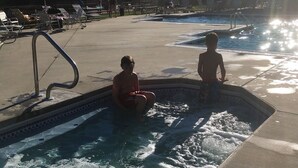 Uma área de piscina com espreguiçadeiras e guarda-sol.