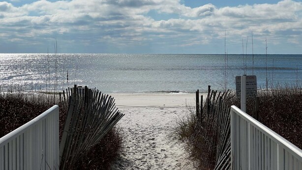 A beach path leading to the shore with a signboard. - Sugar Beach 122 by ALBVR - Nice Studio Condo with New Sofa, AC and Smart TV (Orange Beach)