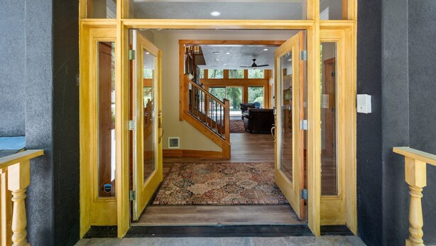 A grand entrance with a wooden staircase leading to a living area. - Riverfront, Hot Tub, Starlink Internet, Basketball! (Durango)