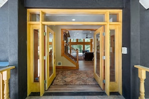 A grand entrance with a wooden staircase leading to a living area.