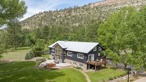 A two-story house with a deck and a large front yard. - Riverfront, Hot Tub, Starlink Internet, Basketball! (Durango)