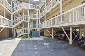 Un parking à plusieurs niveaux, doté d’un escalier central, de nombreux balcons et d’une zone de stationnement couverte.