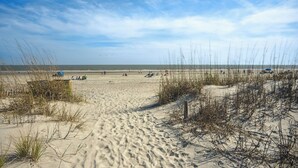 A sandy beach with sparse vegetation and a clear sky. - Breakers 110 - 1st Floor Ocean Front Condo (Hilton Head Island)