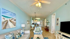 A living room with a sofa, coffee table, TV, and artwork. - Island Royale P403 – Penthouse-Level Beachfront Luxury with Stunning Views (Gulf Shores)