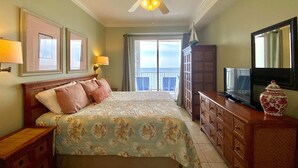 A hotel room with a bed, a television, a dresser, and a ceiling fan. - Island Royale P403 – Penthouse-Level Beachfront Luxury with Stunning Views (Gulf Shores)