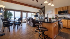A spacious kitchen with a large island, wooden cabinets, and a stone accent wall.