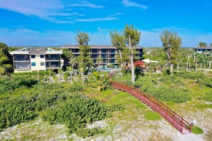 Un resort con edificios de varios pisos, un puente y abundante vegetación.