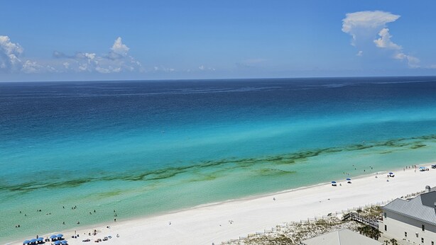 A beach with clear turquoise waters, a sandy shore, and a few umbrellas. - 4828 Beachfront 3BR | 16th Floor | Two Masters | Private Beach + Tram Access (Miramar Beach)