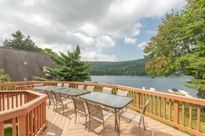 Enjoy a serene view of the water from this deck, surrounded by a railing and featuring a table and chairs.