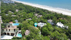 Un quartier résidentiel situé sur la côte, offrant une vue sur la plage, une végétation luxuriante et une piscine.