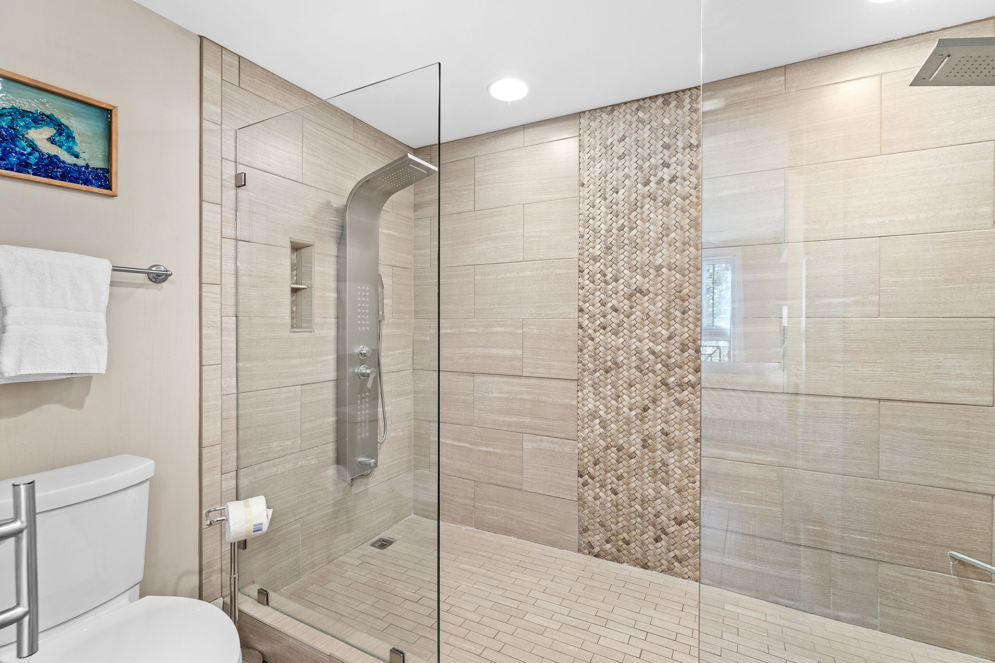 Un baño moderno con ducha de vidrio, inodoro y barra para toallas.