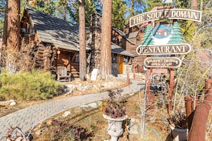 Experience the serene atmosphere of The Soul Domain Restaurant, nestled among tall trees and a paved path.