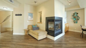 Una sala de estar con chimenea, un sofá, una mesa de centro y un comedor.