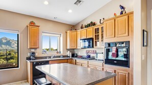 A modern kitchen with wooden cabinets, a granite countertop, and a large island.