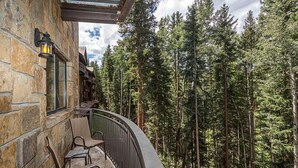 A stone building with a balcony overlooking a forest. - Spacious Renovated 2-Bedroom Mountain Village Escape (Mountain Village)