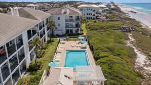 Un resort con piscina, varios balcones y vista al mar.