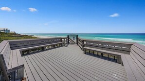 Un muelle de madera que conduce a una playa con vistas despejadas del océano.