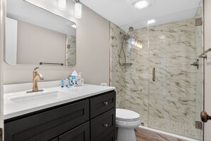 Une salle de bain moderne avec un lavabo, un miroir et des articles de toilette.