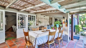 A dining area with a table set for four, surrounded by wooden chairs. - Inn Style Guesthouse (Cape Town)