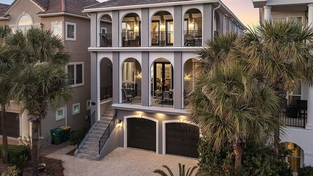 Ein zweistöckiges Haus mit Balkon, Treppe und Garage.