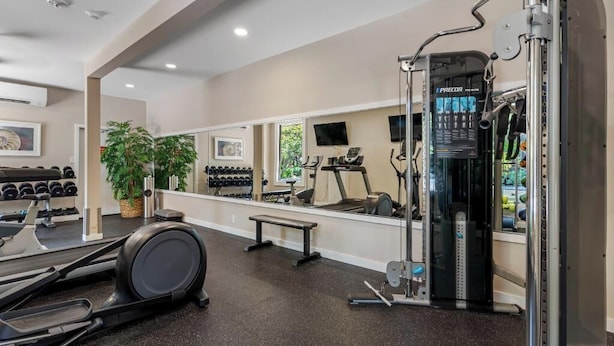 A gym with treadmills, dumbbells, and a weight machine.