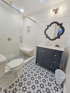 A bathroom with a shower, toilet, vanity, and a mirror. - High 5! Mainsail Townhome! Dedicated covered parking Private Beach! FREE beach set up included. (Destin)