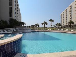 A swimming pool with a 3½ ft depth marker, surrounded by lounge chairs and palm trees. - High 5! Mainsail Townhome! Dedicated covered parking Private Beach! FREE beach set up included. (Destin)