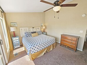 A bedroom with a bed, a dresser, a nightstand, a ceiling fan, and a window. - High 5! Mainsail Townhome! Dedicated covered parking Private Beach! FREE beach set up included. (Destin)