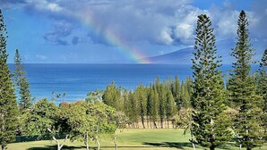 Een golfbaan met uitzicht op de oceaan en een regenboog.