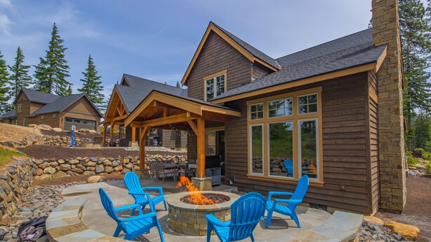 A wooden house with a stone fire pit and blue chairs. - Relax in LUXURY! *Fantastic Discounts* Centrally located in the Resort! (Cle Elum)