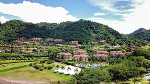 A resort with multiple buildings, a swimming pool, and lush greenery.