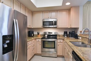 A modern kitchen with stainless steel appliances, a built-in oven, microwave, and a water dispenser. - Open concept, private beach access w/resort amenities! 🏖️ (Destin)