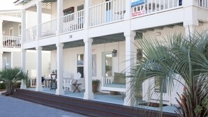 A two-story building with a balcony on the ground floor and a single-story structure above. - Gulf Winds Down 3/2 in Grayton, comm.pool, short walk to beach (Santa Rosa Beach)