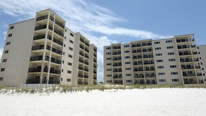 Ett hotell vid stranden med flera våningar, balkonger och en sandstrand framför.