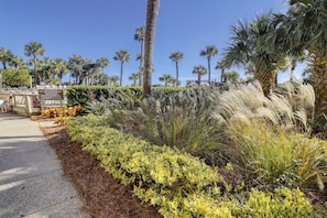A landscaped area with palm trees, a pathway, and a sign indicating a private pool area.